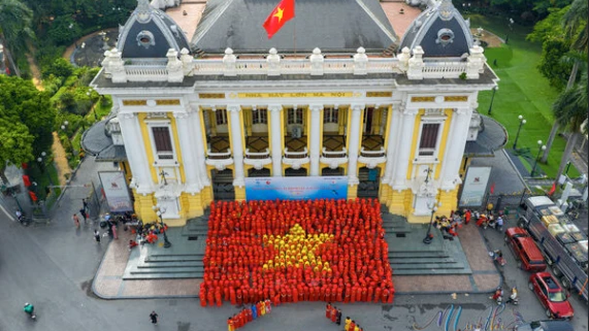 600 femmes de la capitale se produisent en ao dai et forment des blocs en forme de drapeau national devant l'Opéra.