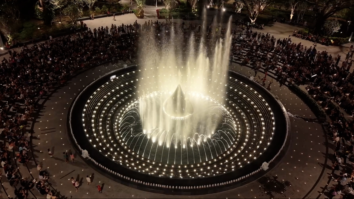 Pessoas aproveitam para assistir ao espetáculo gratuito das fontes de água em um parque na cidade de Ho Chi Minh.