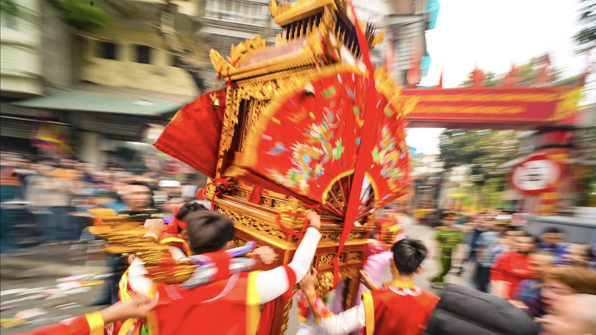Pemuda-pemuda membawa palanquin, berpusing, dan berlari seperti peluncur air di festival Hanoi kuno.