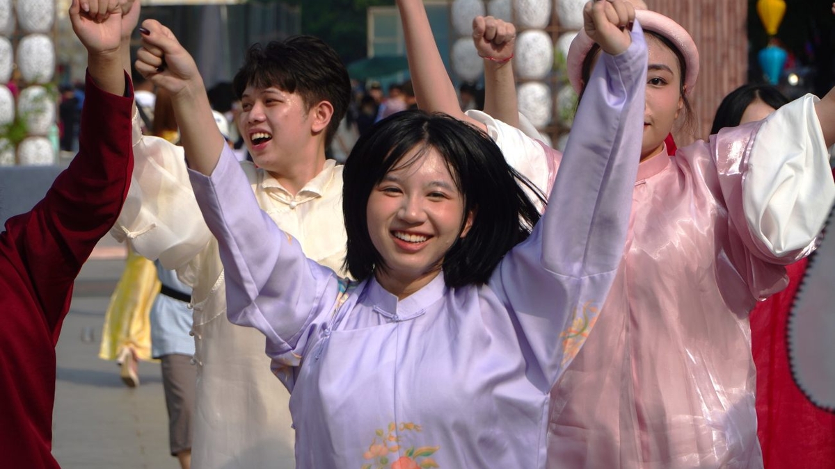 Hombres y mujeres jóvenes vestidos con ao dai y atuendos tradicionales vietnamitas desfilaron por la calle peatonal Nguyen Hue.
