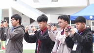 Los estudiantes practican como fotoperiodistas en el torneo de fútbol de los trabajadores.