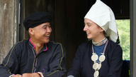 Un tânăr născut în anii 1990 cară pietre de pârâu pentru a construi o casă de vacanță, păstrând identitatea culturală a grupului etnic Dao.
