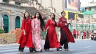 Gaun ao dai yang elegan menghiasi jalanan Kota Ho Chi Minh saat orang-orang menyambut datangnya awal musim semi.