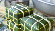 Banh chungin (vietnamilaisen tahmean riisikakun) kääriminen kookospähkinänlehtimuotteihin - Dien Chaun rannikkokyläläisten kaunis kulttuuriperinne.