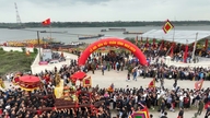 Een plechtige processie met de heilige draagstoel over de rivier tijdens het Va Tempelfestival.