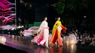 Une reine de beauté met en valeur sa beauté en ao dai (robe traditionnelle vietnamienne) tout en partageant des histoires sur l'artisanat du tissage de la soie au Vietnam.