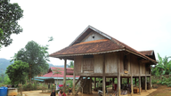 Gamla hus på styltor i Binh Chuan - ett kulturellt landmärke för det thailändska folket mitt i den vidsträckta skogen.