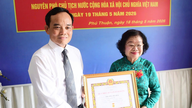 Le secrétaire du Parti, Tran Luu Quang, remet l'insigne d'adhésion au Parti pour 65 ans à l'ancien vice-président Truong My Hoa.