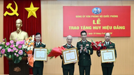 Kenraali Phan Văn Giang luovuttaa puolueen 70-vuotisen jäsenmerkin kenraali Phạm Văn Tràlle.
