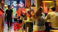 Meja dan kursi plastik, piring nasi yang pecah, dan sekilas pemandangan Kota Ho Chi Minh di Berlin.