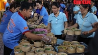 Nuoret miehet pitävät liekkiä yllä ilmaisessa nuudeliravintolassa Ho Chi Minh Cityssä.