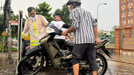 ตำรวจจราจรเมืองอันซวงให้ความช่วยเหลือประชาชนในการข้ามถนนที่ถูกน้ำท่วมอย่างหนัก