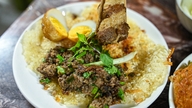 Een 35 jaar oud restaurant dat roergebakken pho serveert, verscholen in een smal steegje in Hanoi, zit zelfs in de verzengende hitte nog steeds vol met klanten.