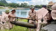 Manuseio seguro de duas grandes bombas não detonadas, remanescentes da guerra.