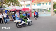 An Giang: Pegawai polis mengangkut pelajar yang terlajak tidur ke tempat peperiksaan.