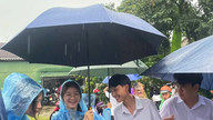 អ្នកស្ម័គ្រចិត្តវ័យក្មេងហ៊ានប្រឈមមុខនឹងភ្លៀង ដើម្បីគាំទ្របេក្ខជនប្រឡង។