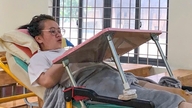 Een vrouwelijke studente ligt op een brancard tijdens haar eindexamen.