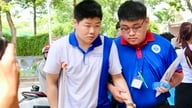 Студент, передвигаясь на костылях, вошел в экзаменационную комнату при поддержке незнакомых людей.