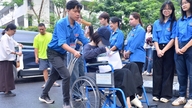 Kvindelig studerende i Hanoi går ind i en kørestolslokale til en afgangseksamen på gymnasiet.