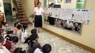 The woman quietly 'plants the seeds' of self-confidence in children.