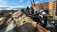 Reddingsteams van de politie zoeken naar 15 mensen die vastzitten in een ingestort gebouw in Venezuela.