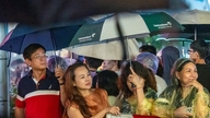 למרות הגשם, אלפי אנשים עדיין נהרו למרכז העיר כדי לצפות בזיקוקים שחגגו 50 שנה להו צ'י מין סיטי.