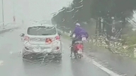 În Quang Ninh, vânturi puternice au lovit zona, determinând șoferii să încetinească și să își protejeze motocicletele de furtună.