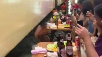 하노이의 기차길에서 기차가 테이블과 의자를 쓰러뜨리자 서양 관광객들은 비명을 질렀습니다.