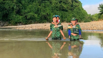 ឆ្មាំ​ព្រំដែន​ដឹក​កុមារ​ឆ្លង​កាត់​អូរ​ទៅ​សាលា​នៅ​ថ្ងៃ​បើក។