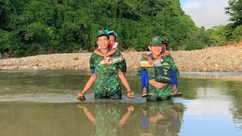 ឆ្មាំព្រំដែនដឹកសិស្សឆ្លងកាត់អូរទៅសាលារៀនសម្រាប់ពិធីបើកឆ្នាំសិក្សាថ្មី។