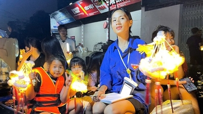 하노이 어린이들이 '홍수 센터' 구역에서 보트를 타고 중추절을 축하하기 위해 등불을 들고 있습니다.