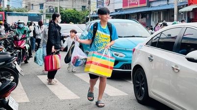 Die Menschen kehren nach dem Urlaub mit Taschen in der Hand nach Ho-Chi-Minh-Stadt zurück