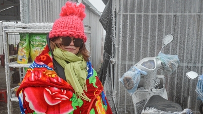 Tourists wrapped in blankets climb Mau Son peak to experience the ice