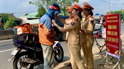 មន្ត្រីនគរបាលចរាចរណ៍ស្រីនៅខេត្ត Quang Nam ផ្តល់ និងពាក់មួកសុវត្ថិភាពជូនប្រជាពលរដ្ឋពេលធ្វើដំណើរទៅផ្ទះ Tet