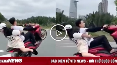 Young man carrying girl doing a wheelie on motorbike causes outrage