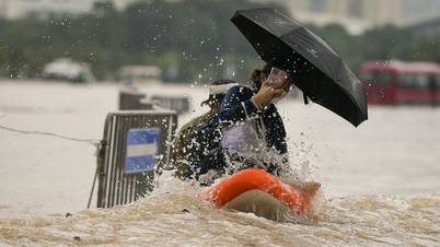 雨が降り注ぎ、通りは川と化し、ハノイの人々はボートで通りを行き来した。