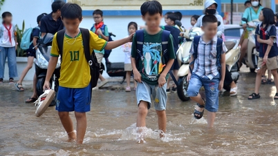 Hanoi is sunny, but students still wade through the water to go home.