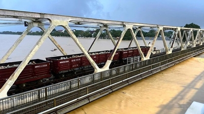 Terwijl de Huong-rivier buiten zijn oevers treedt, stuurt de spoorlijn nog steeds twee schepen met 1.100 ton stenen naar de brug om deze te ondersteunen.