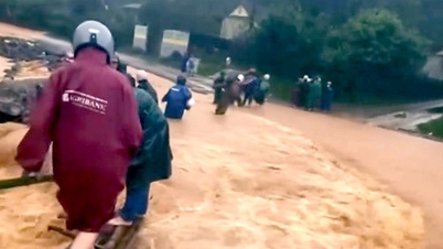 Profesorii au instalat un pod temporar pentru a traversa apele inundațiilor, susținut de 4 stâlpi de lemn.