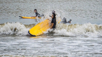 Toeristen gaan surfen op het strand voordat tyfoon Kalmaegi nadert