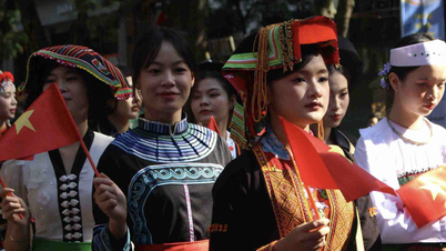 Západní turisty zahlcují tisíce lidí pochodujících na ao dai v Hanoji.