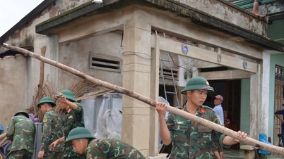 חיילי קוואנג נגאי עוזרים לתושבי קהילת נגוין נגיים להתגבר על תוצאות הטורנדו.