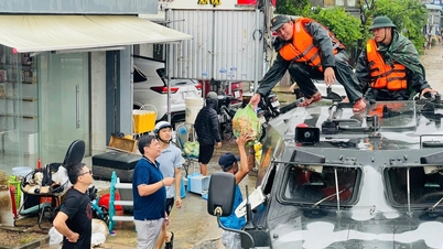 Gepantserde voertuigen steken de overstromingen over en voorzien mensen van noodvoedsel