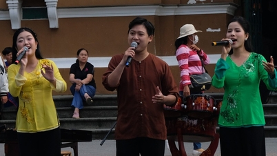 ホーチミン市郵便局でベトナムの民謡を楽しむ外国人観光客