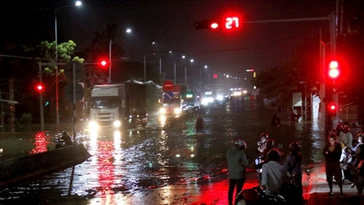 Rising floodwaters inundate National Highway 1A through Ham Thang ward.