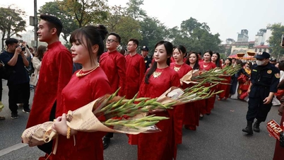 수백 명의 사람들이 모인 결혼 행렬이 하노이 중심부에서 고대 결혼식을 재현합니다.