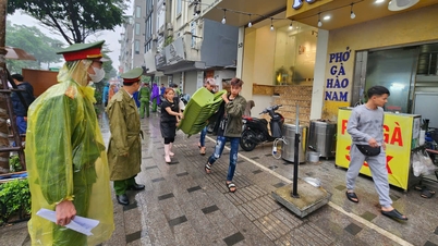 Autoridades distritais de Hanói enfrentam a chuva para realizar uma "campanha" com o objetivo de recuperar as calçadas para os pedestres.