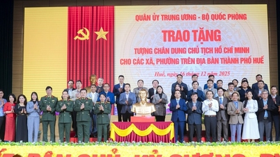Mempersembahkan patung potret Presiden Ho Chi Minh kepada 40 komun dan wad di Bandar Hue.