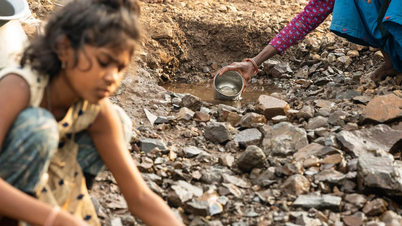 Una colegiala india falta a la escuela para llevar agua.