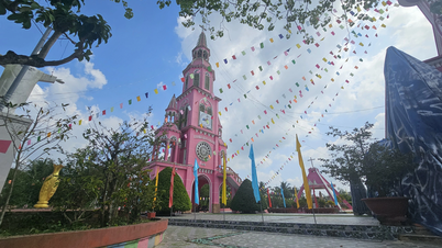 Eine rosafarbene Kirche inmitten grüner Gärten in der westlichen Region, inspiriert von der Tan-Dinh-Kirche.